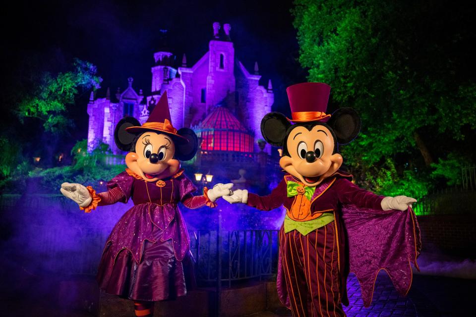 Minnie and Mickey Mouse, dressed in their Halloween best, welcome guests to Mickey’s Not-So-Scary Halloween Party at Disney's Magic Kingdom.