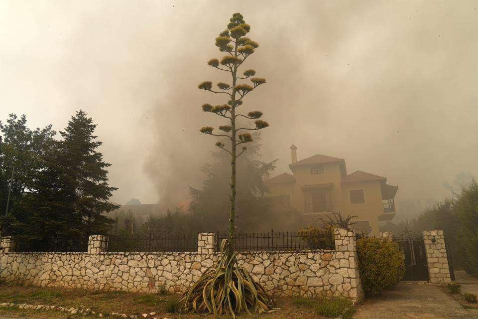 A house is on fire in Afidnes village, about 31 kilometres (19 miles), north of Athens, Greece, Friday, Aug. 6, 2021. Thousands of people fled wildfires burning out of control in Greece and Turkey on Friday, as a protracted heat wave turned forests into tinderboxes and flames threatened populated areas, electricity installations and historic sites. (AP Photo/Thanassis Stavrakis)