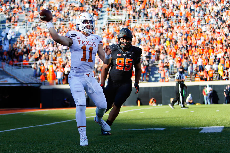 STILLWATER, OK - OCTOBER 31:  Quarterback Sam Ehlinger #11 of the Texas Longhorns throws the ball away after getting flushed out of the pocket by defensive tackle Israel Antwine #95 of the Oklahoma State Cowboys in the second quarter at Boone Pickens Stadium on October 31, 2020 in Stillwater, Oklahoma.  (Photo by Brian Bahr/Getty Images)