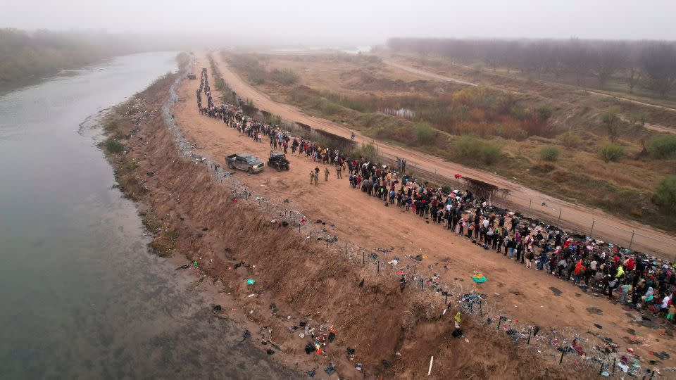 Migrants gather near the border in Eagle Pass after crossing the Rio Bravo river with the intention of turning themselves in to US Border Patrol agents to request asylum on December 23. - Jose Luis Gonzalez/Reuters