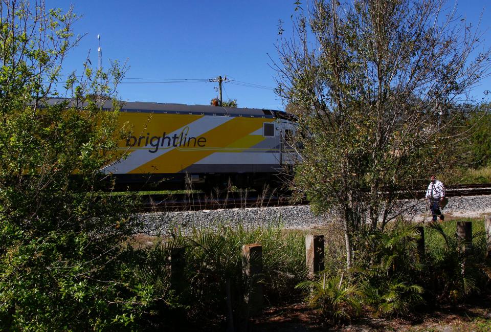 An investigator walks the tracks as a Brightline train passes near the 1800 block of Old Dixie Highway SW where a man was hit by a Brightline train Monday evening.