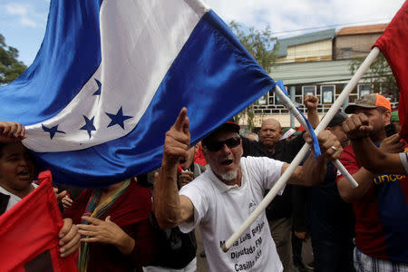 A supporter of Salvador Nasralla, presidential candidate for the Opposition Alliance Against the Dictatorship, gestures while holding a Honduras national flag during a protest in Tegucigalpa, Honduras, November 29, 2017. REUTERS/Jorge Cabrera