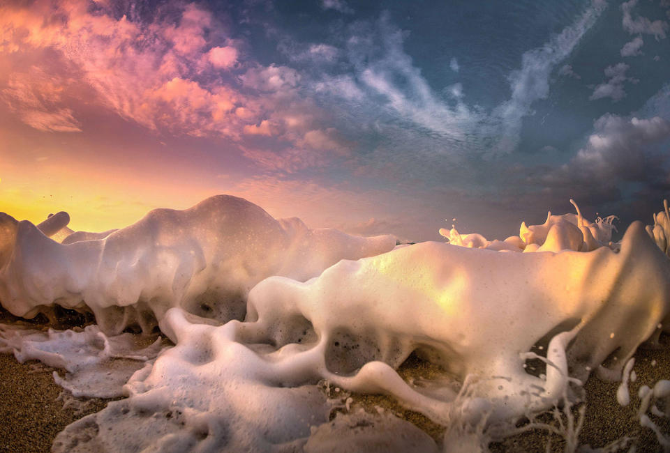 <p>Light and foamy surf laps the beach in the wake of a storm in Oahu. (Photo: Marco Mitre/Caters News) </p>