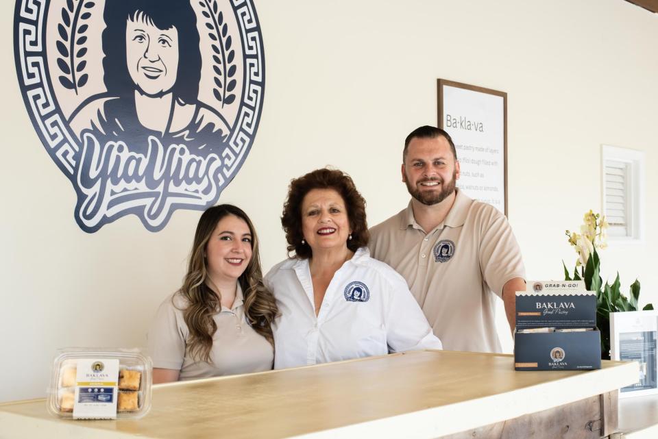 Christine Samaras, center, stands with her daughter-in-law, Leticia, and son, Dimitri, inside their new retail shop on Friday, May 12, 2023.