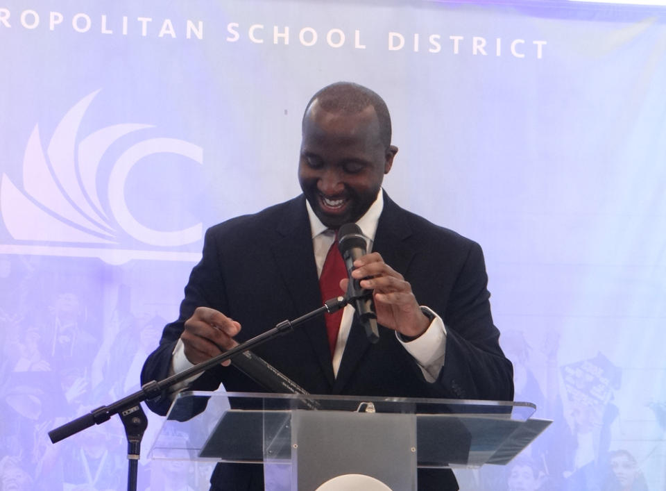 <em>New Cleveland schools CEO Warren Morgan holds the baton given to him by outgoing CEO Eric Gordon to symbolize the passing of leadership in the district.</em> (<em>Patrick O’Donnell</em>)