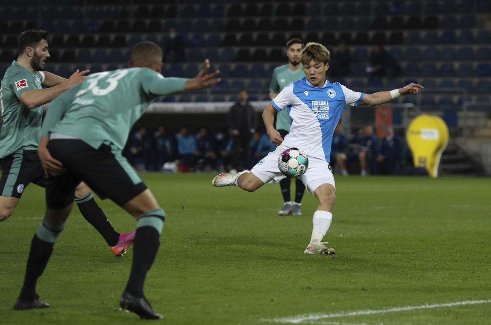 El delantero del Arminia Belefeld Ritsu Doan tira en el encuentro ante el Schalke 04 en la Bundesliga. La derrota confirmó el descenso del Schalke el martes 20 de abril del 2021. (Friso Gentsch/pool via AP)