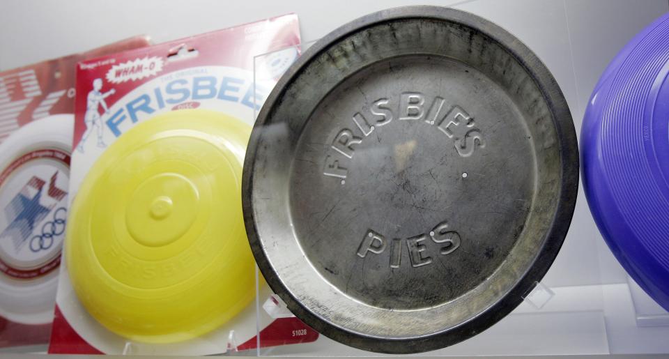 An original Frisbie pie tin on display with modern plastic Frisbees at the National Toy Hall of Fame at the Strong National Museum of Play in Rochester, N.Y.