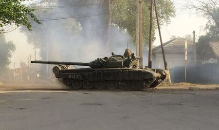 A tank drives along a street of the Russian southern town of Matveev Kurgan, near the Russian-Ukrainian border in Rostov region, Russia, May 26, 2015. The convoy of nine tanks, which were delivered by train the day before, drove along streets of the town on Tuesday, according to a Reuters journalist. REUTERS/Maria Tsvetkova