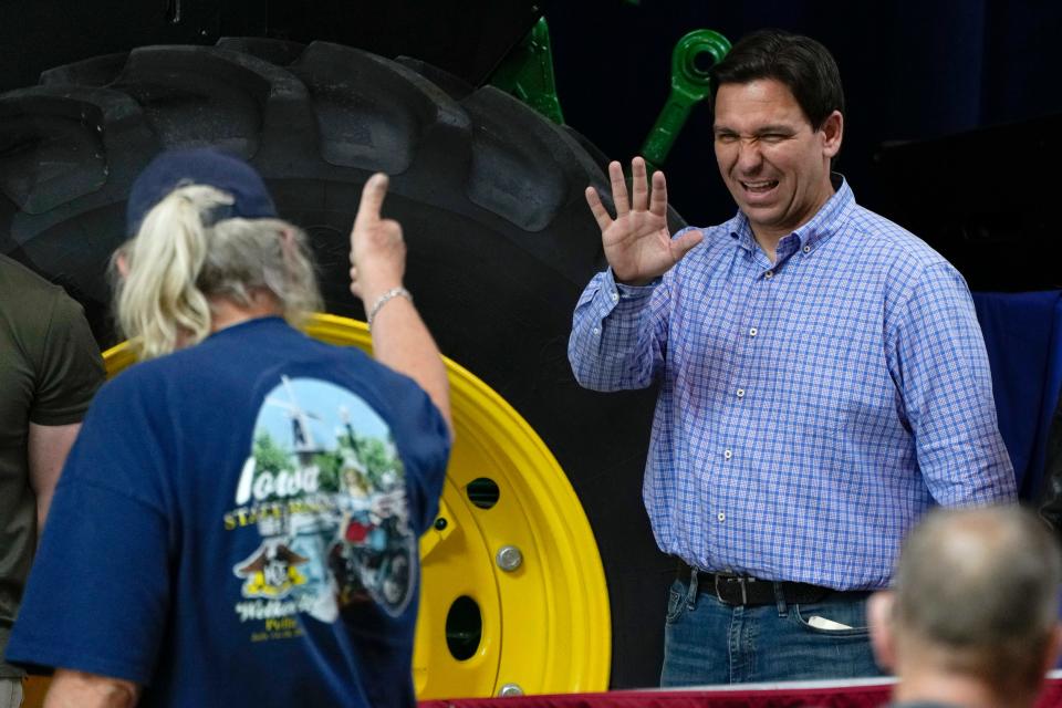 ron desantis waves at a man giving him a thumbs up