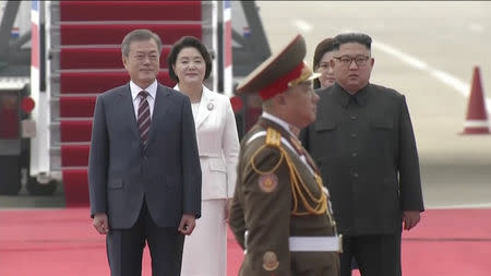 North Korean leader Kim Jong Un and his wife Ri Sol Ju along with South Korean President Moon Jae-in and First Lady Kim Jung-sook review honour guards at Pyongyang Sunan International Airport, North Korea ahead of the third summit with North Korean leader Kim Jong Un in this still frame taken from video September 18, 2018. KBS/via REUTERS TV