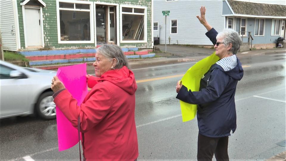 About a half dozen people held up signs outside the local MLA's office, catching the attention of passing vehicles.