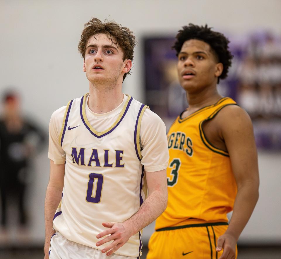 St. Xavier's Cole Edelen (0) and St. Xavier's Jeremiah Jackson (23) watched Edelen's long, late three-pointer cut the St. X Tigers' lead Monday night at Male High School.  Saint Xavier defeated Male 80-77.  February 12, 2024