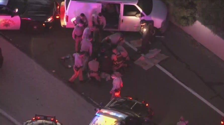 Officers swarmed the van, opening the back sliding door and dragging the man outside. (KTLA)