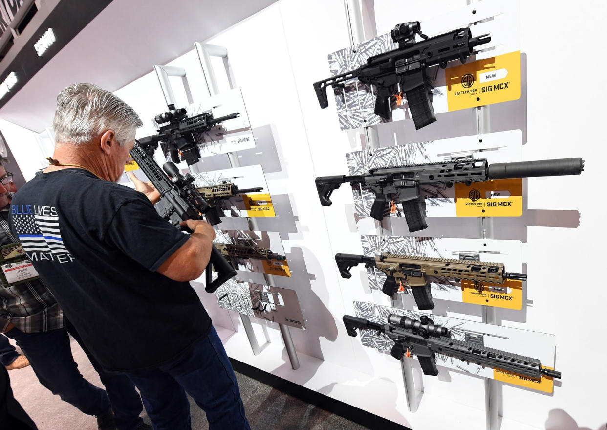 Image: A convention attendee looks at rifles at the National Shooting Sports Foundation's annual trade show in 2018 in Las Vegas. (Ethan Miller / Getty Images file)
