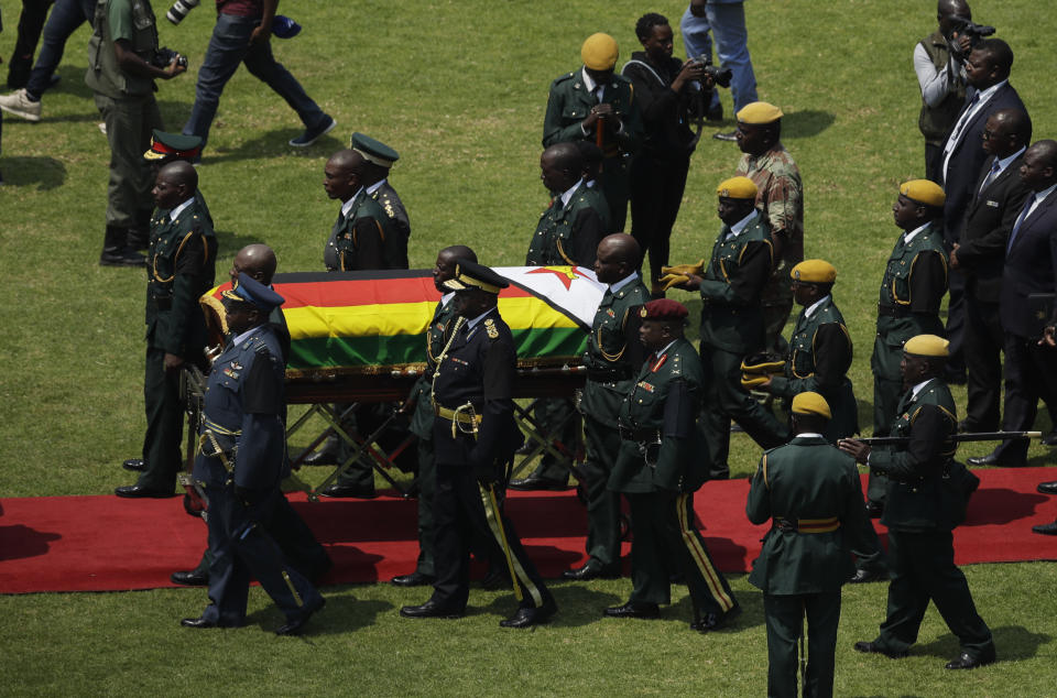 Former Zimbabwean President Robert Mugabe's casket arrives for a state funeral for at the National Sports Stadium in Harare, Saturday, Sept. 14, 2019. African heads of state and envoys are gathering to attend a state funeral for Mugabe, whose burial has been delayed for at least a month until a special mausoleum can be built for his remains. (AP Photo/Themba Hadebe)