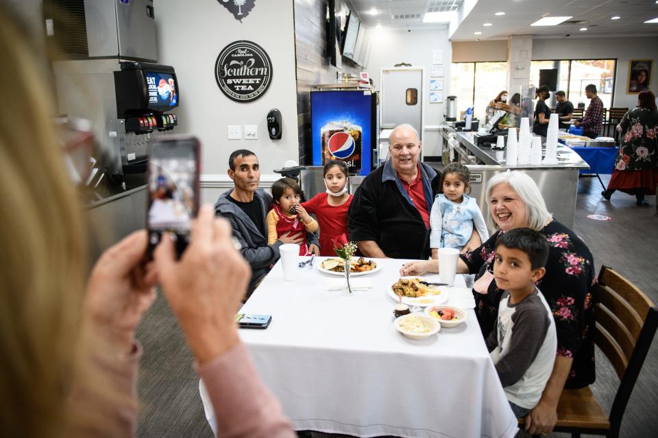 Kim Hasty, left, takes a photo of some of the Habibi family with their sponsor family the barefoot family during a meet up of recent Afghan refugees, veterans and others at Afghan Kabob on Sunday, Nov. 14, 2021.