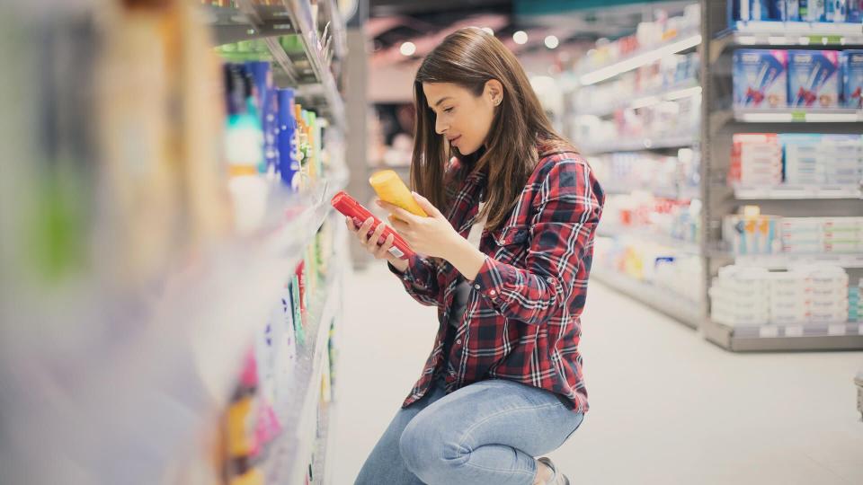 Woman choosing sunscreen lotion.