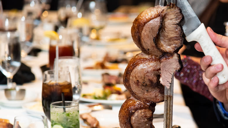 carving picanha beef on skewer