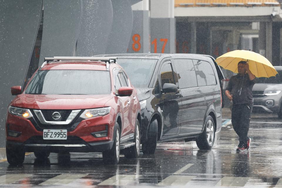 A man carrying an umbrella walks in the rain outside Taipei Songshan Airport as Typhoon Gaemi approaches in Taipei, Taiwan (REUTERS)