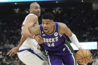 Los Angeles Clippers' Nicolas Batum fouls Milwaukee Bucks' Giannis Antetokounmpo during the first half of an NBA basketball game Thursday, Feb. 2, 2023, in Milwaukee. (AP Photo/Morry Gash)