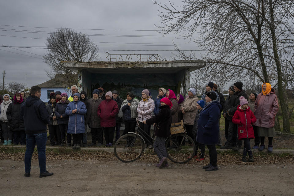 The head of the local administration talks with the residents of Znamianka during a visit to the village after Russian troops withdrew from the Kherson region, southern Ukraine, Sunday, Nov. 13, 2022. Families were torn apart when Russia invaded in February, as some fled and others hunkered down. Now many are seeing one another for the first time in months, after Moscow's latest retreat amid a Ukrainian counteroffensive that has retaken a pocket of territory wedged between the regional capitals of Kherson and Mykolaiv and the Black Sea. (AP Photo/Bernat Armangue)