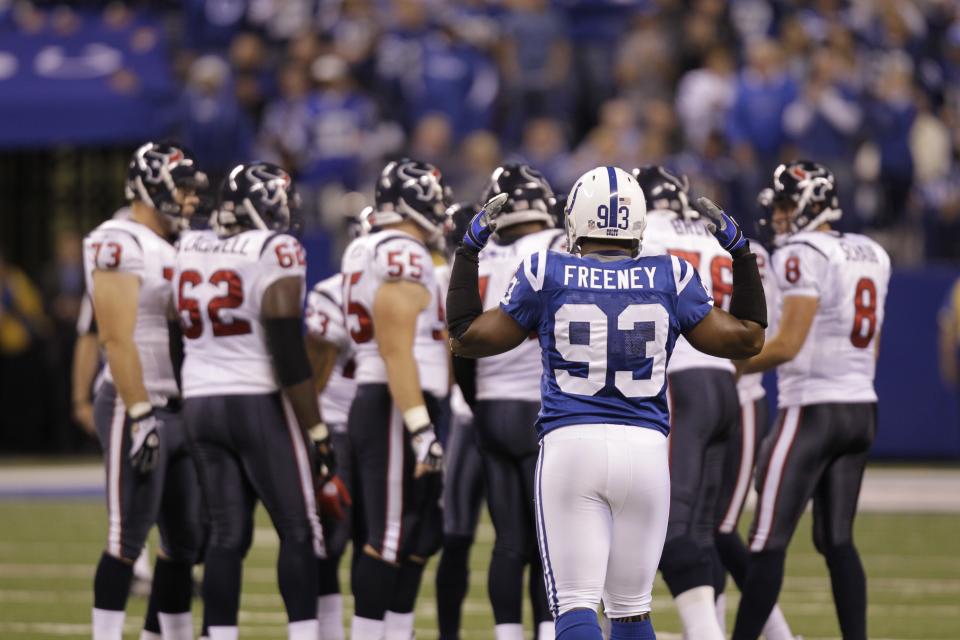 Indianapolis Colts defensive end Dwight Freeney encourages the crowd as the Houston Texans huddle in the first quarter of an NFL football game in Indianapolis, Monday, Nov. 1, 2010. (AP Photo/Michael Conroy)