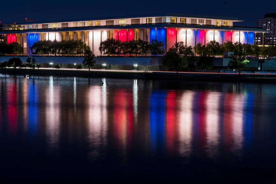 The red, white and blue lights, marking the 100th birthday of President John F. Kennedy, on the outside of the Kennedy Center for the Performing Arts are reflected in the Potomac River in Washington, D.C., in this May 26, 2017, file photo.