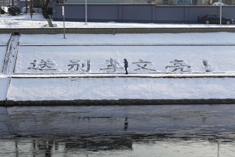 不知名的北京市民在積雪上寫著：送別李文亮！（美聯社）