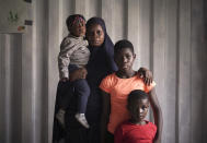 Single mother Fatima Abdul, from Nigeria, and her children from left to right, Faridos, almost 2, Fawas, 13, and Quadri, 7, pose for a portrait aboard the humanitarian rescue ship Ocean Viking, in Italian waters off the Sicilian town of Messina, southern Italy, Monday, Sept. 23, 2019, hours before disembarking. Fatima feared for her children’s safety and left Nigeria. Her youngest daughter who will be turning 2 soon may not remember their time in Libya. But the other two boys age 13 and 7 do. “It was a very bad place” the eldest said. (AP Photo/Renata Brito)