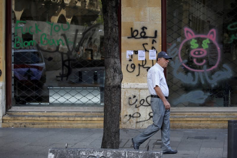 A man walks past a closed bank office in Beirut