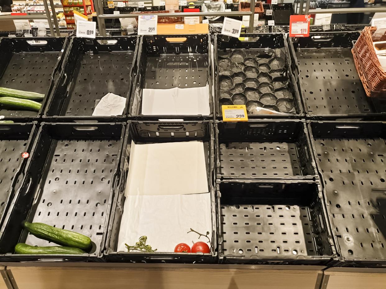 Nearly empty vegetable crates in a grocery store