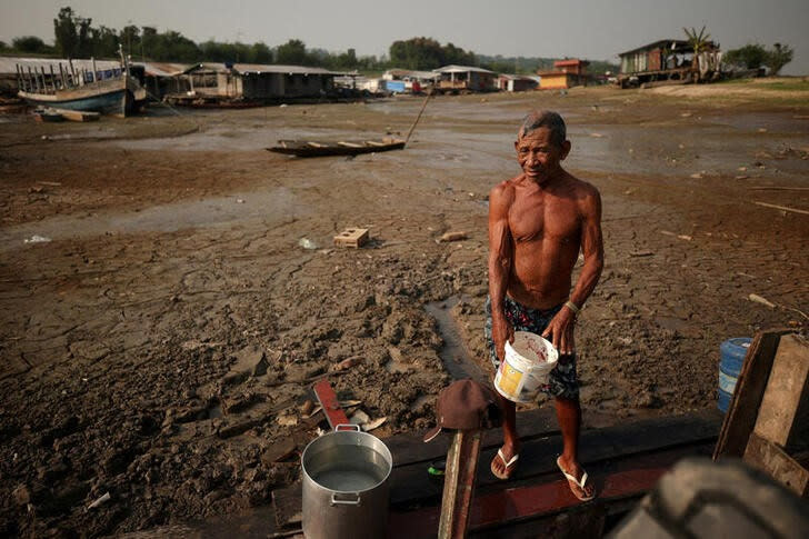 El pescador Raimundo da Silva do Carmo, de 67 años, recoge agua de un pozo en el lago Puraquequara, afectado por la sequía, en Manaos, Brasil.