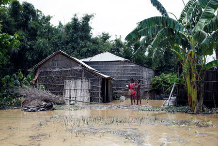 Flood victims stands near a house in Saptari District, Nepal August 14, 2017. REUTERS/Navesh Chitrakar