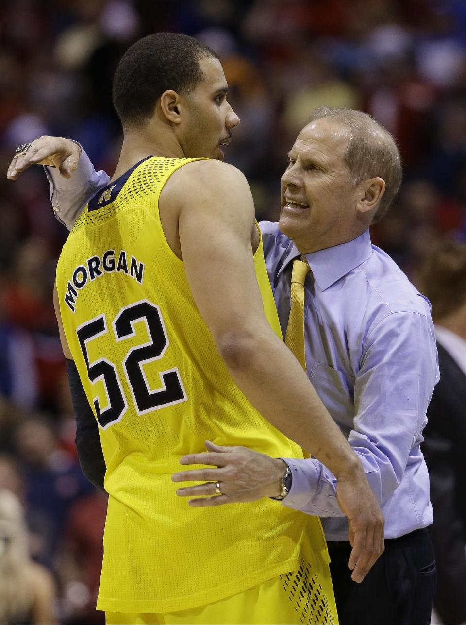 Michigan head coach John Beilein celebrates with Jordan Morgan (52) after an NCAA Midwest Regional semifinal college basketball tournament game against the Tennessee Friday, March 28, 2014, in Indianapolis. Michigan won 73-71.(AP Photo/David J. Phillip)