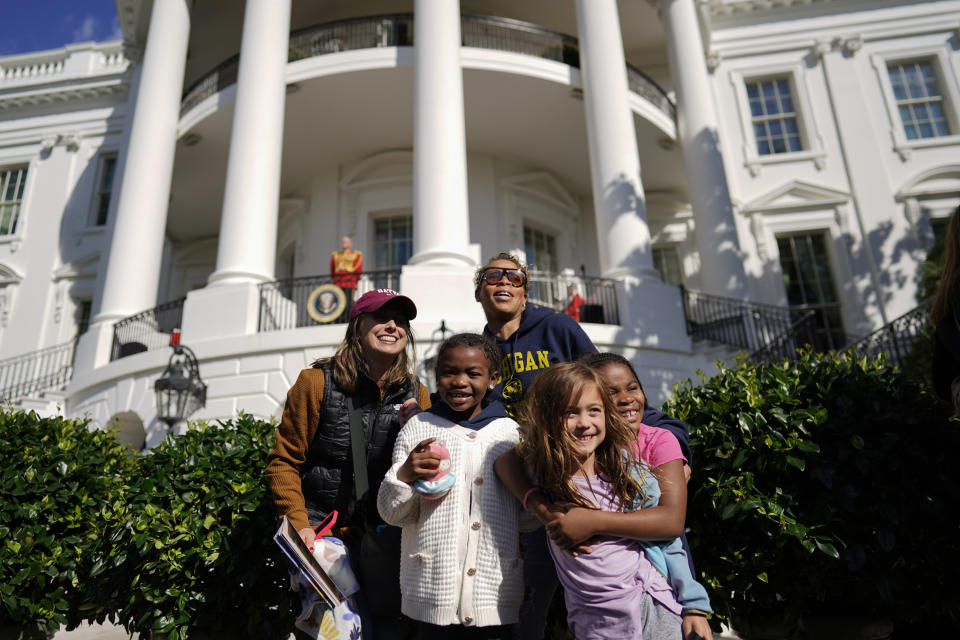 Lauren Serpe, back left, and Rashida Holman-Jones pose for photos with their kids from left, Zynn Jones, Sydney Serpe, and Zuri Jones, during the White House Fall Garden Tour in Washington, Saturday, Oct. 8, 2022. (AP Photo/Carolyn Kaster)