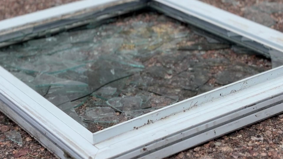 The broken window along with shattered glass could be visible out front of the property.