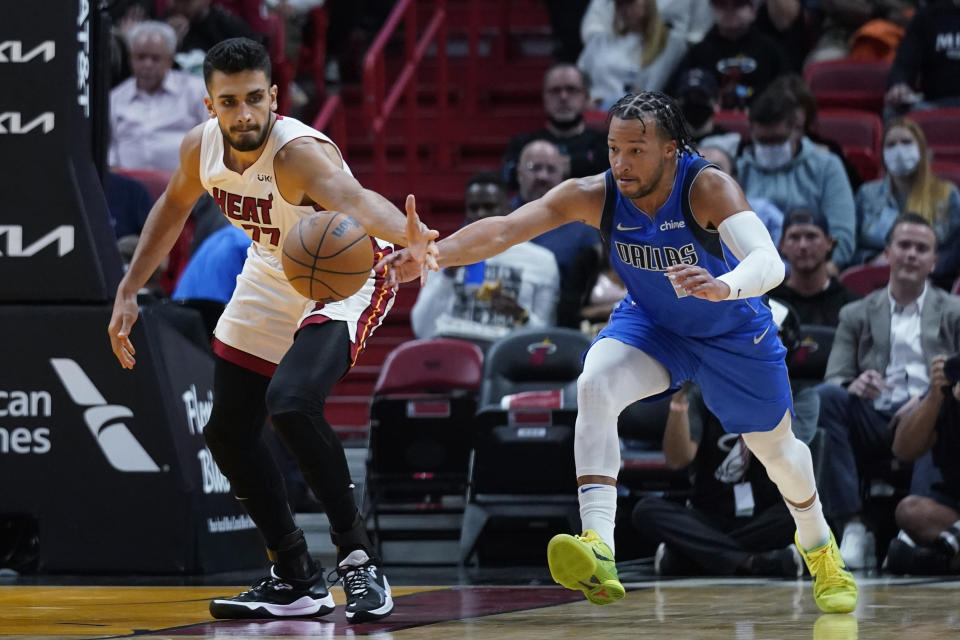 Miami Heat center Omer Yurtseven, left, and Dallas Mavericks guard Jalen Brunson vie for a loose ball during the first half of an NBA basketball game, Tuesday, Feb. 15, 2022, in Miami. (AP Photo/Wilfredo Lee)