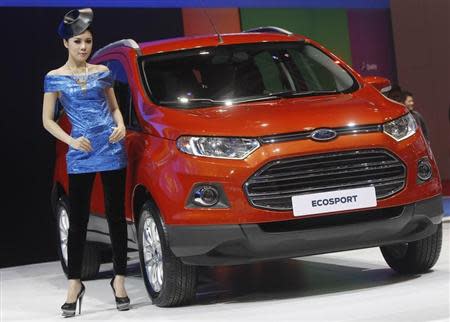 A model poses beside a Ford Ecosport during a media presentation of the 34th Bangkok International Motor Show in Bangkok March 26, 2013. REUTERS/Chaiwat Subprasom