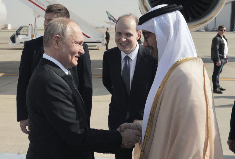 Esta fotografía distribuida por la agencia estatal rusa Sputnik muestra al presidente de Rusia, Vladimir Putin, estrechando la mano del ministro de Relaciones Exteriores de Emiratos Árabes Unidos, el jeque Abdullah Bin Zayed, a su llegada al aeropuerto de Abu Dhabi el 6 de diciembre de 2023.