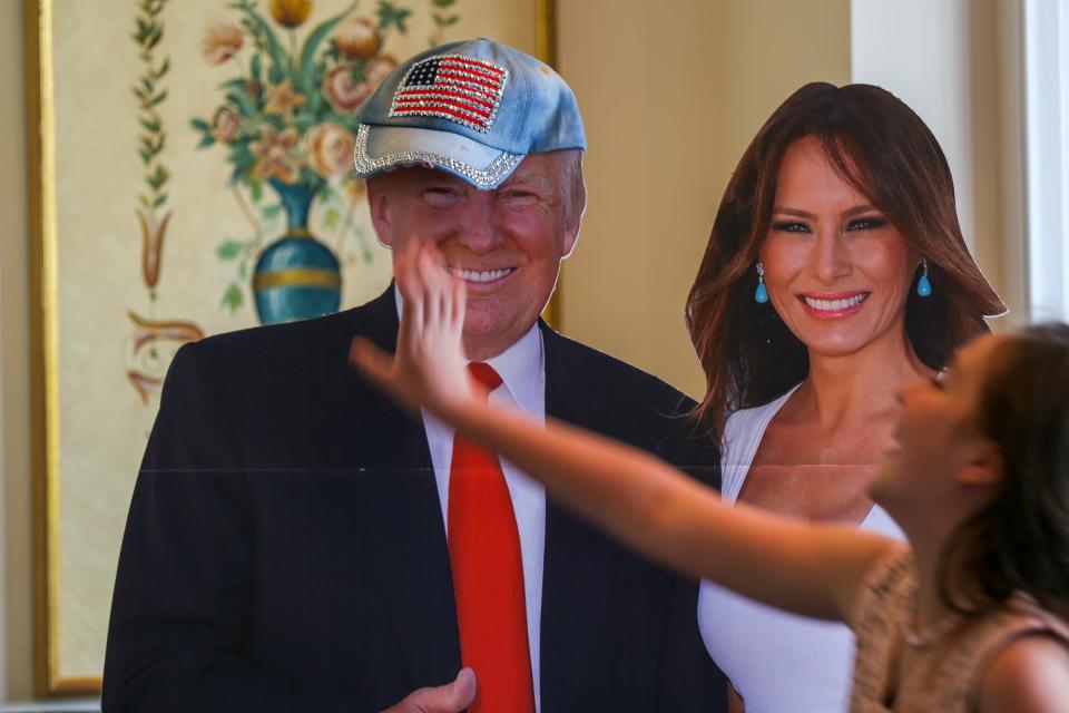 A young conservative places a bedazzled cap on top of a cutout of U.S. President Donald Trump during a Women for Trump luncheon organized by the Michigan Trump Republicans at the Heathers Club in Bloomfield Hills, Mich. on Friday, July 26, 2019. 