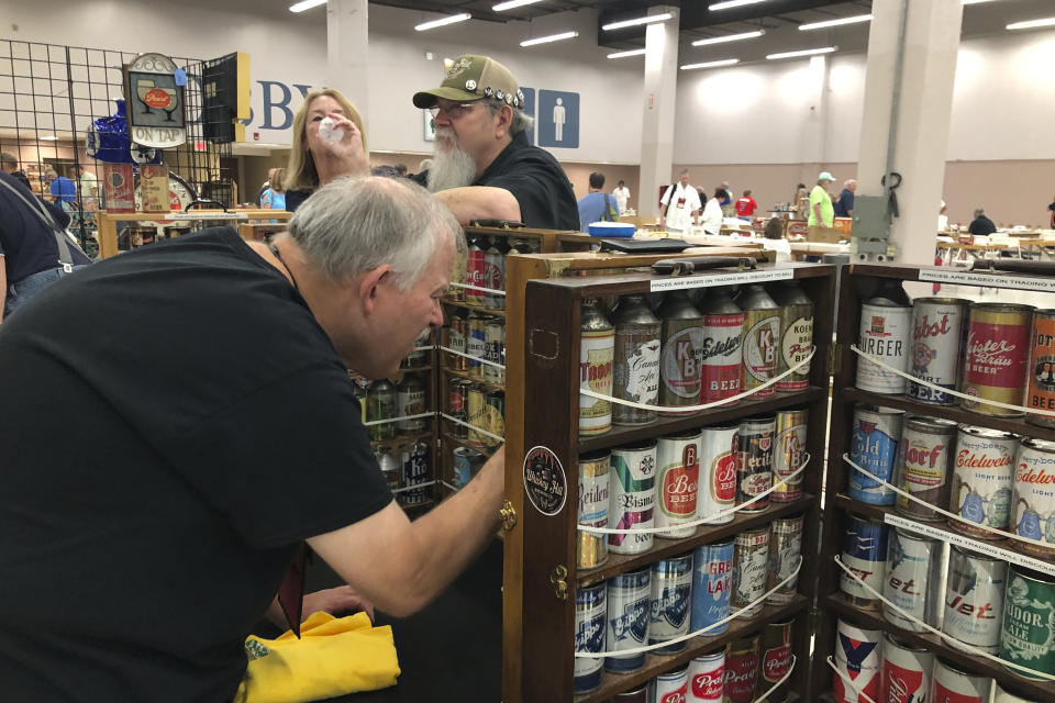 A collector looks through vintage beer cans on display Thursday, Aug. 29, 2019, in Albuquerque, N.M., at the 49th annual gathering of members of the Brewery Collectibles Club of America. Collectors from around the world began Thursday buying, trading and selling containers of brews at the annual four-day event billed the "CANvention." (AP Photo/Russell Contreras)