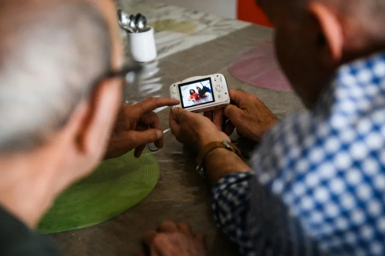 Un paciente con alzheimer (izq.) participa en un taller de fotografía el 9 de mayo de 2023 en una residencia en Arles, en el sureste de Francia (Clement Mahoudeau)