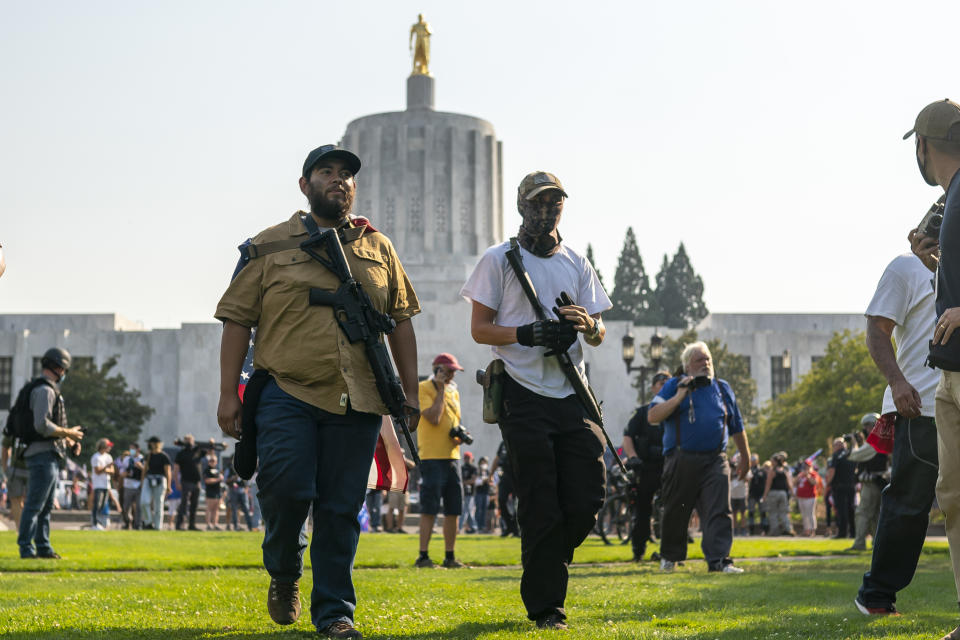 Far-right protesters walk past the state capitol with long rifles during a rally on September 7, 2020 in Salem, Oregon. A Pro-Trump caravan drove into the Oregon state capitol Monday afternoon where far-right protesters clashed with counter protesters.  (Nathan Howard/Getty Images)