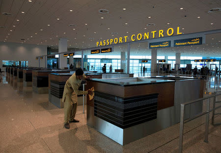 A worker cleans a passport control counter during a media tour of the newly built Islamabad International Airport, ahead of its official opening, Pakistan April 18, 2018. REUTERS/Faisal Mahmood