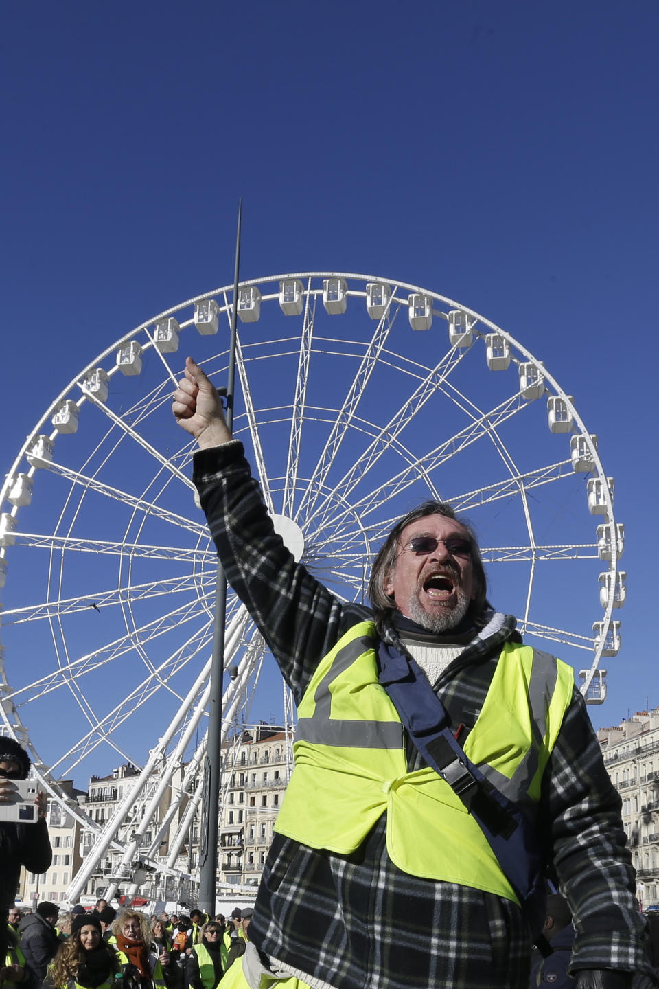 A yellow vest protester demonstrates peacefully in downtown Marseille, southern France, Saturday, Jan. 12, 2019. Authorities deployed 80,000 security forces nationwide for a ninth straight weekend of anti-government protests. (AP Photo/Claude Paris)