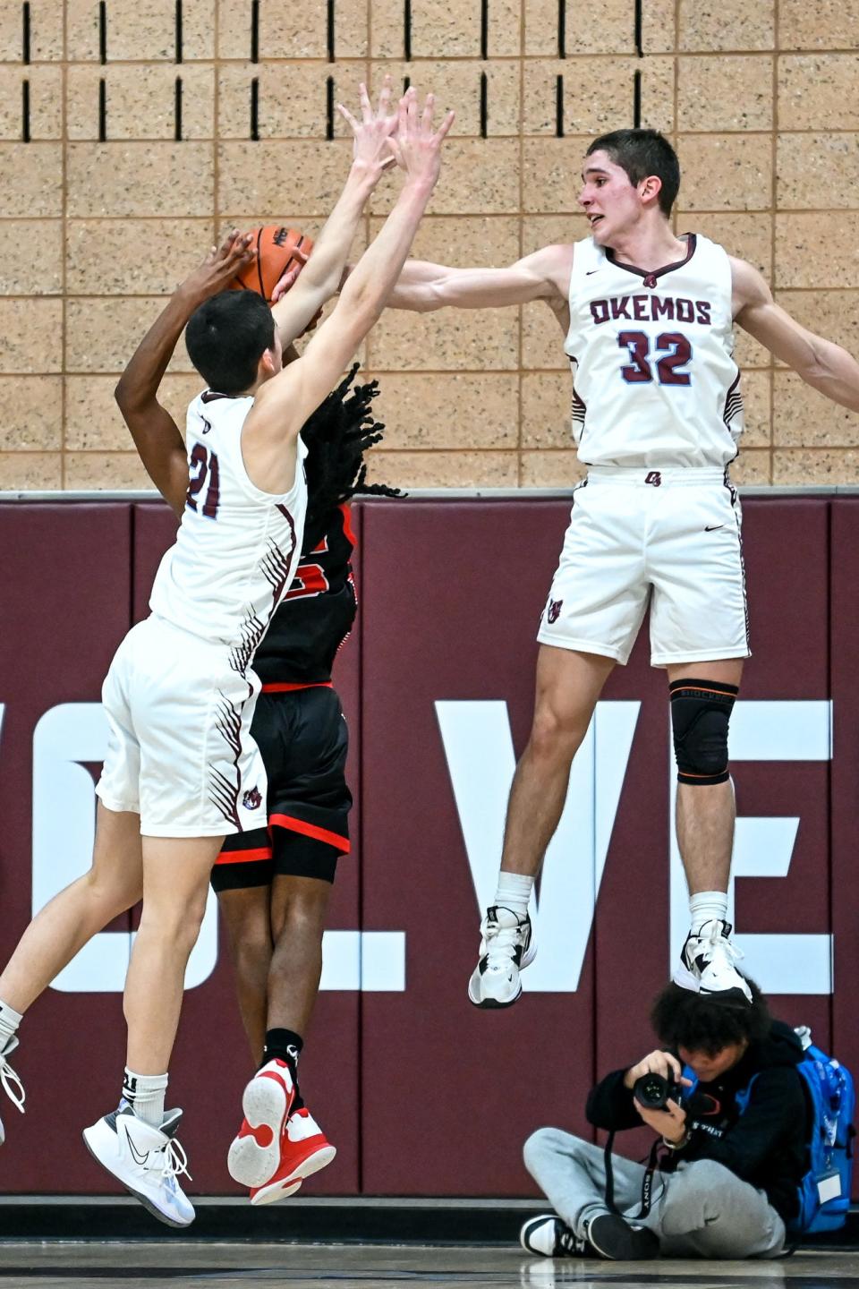 Okemos' Hudson Grienke, left, and Collin Alexander, right, block a shot by Sexton's Daquarious Alexander during the fourth quarter on Tuesday, Dec. 6, 2022, at Okemos High School.