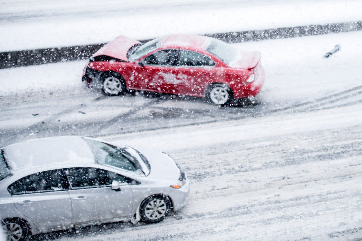 A car collision happens in heavy snow. 