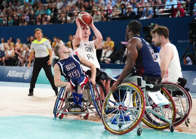 Great Britain's Phil Pratt, centre left, attempts a shot under pressure from the United States' John Boie, left, in the Paralympic men's wheelchair basketball final