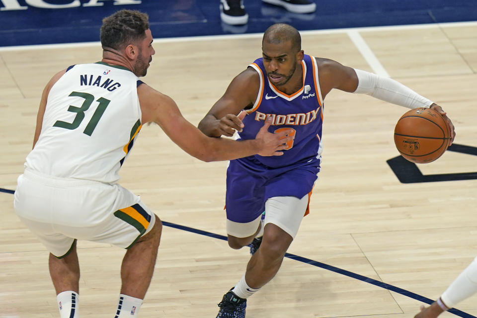 Phoenix Suns Chris Paul, right, drives as Utah Jazz forward Georges Niang, left, defends during the first half of an NBA preseason basketball game Monday, Dec. 14, 2020, in Salt Lake City. (AP Photo/Rick Bowmer)