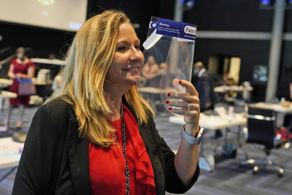 FILE - In this Tuesday Aug. 18, 2020, file photo Virginia State Sen. Amanda Chase, R-Chesterfield, arrives in the temporary Senate chambers at the Science Museum of Virginia prior to the start of the Senate session at the facility in Richmond, Va. The top GOP contenders for governor in Virginia say “election integrity” is a high priority. The candidates say change is needed to restore credibility to the voting process, whether that involves tightening voter ID laws, making the Department of Elections politically independent, or cleaning up voter rolls.(AP Photo/Steve Helber, File)